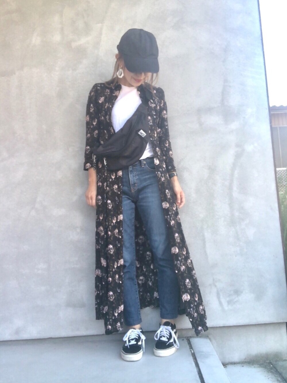 ブラック系のボディバッグ/ウエストポーチ、ブルー系のデニムパンツ、ブラック系のスニーカーを着用したレディースの秋コーディネートの1枚目の写真