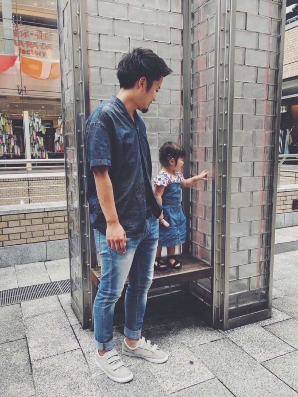 ブルー系のジャンパースカート、ホワイト系のTシャツ/カットソー、ブラック系のサンダルを着用したメンズの夏コーディネートの1枚目の写真