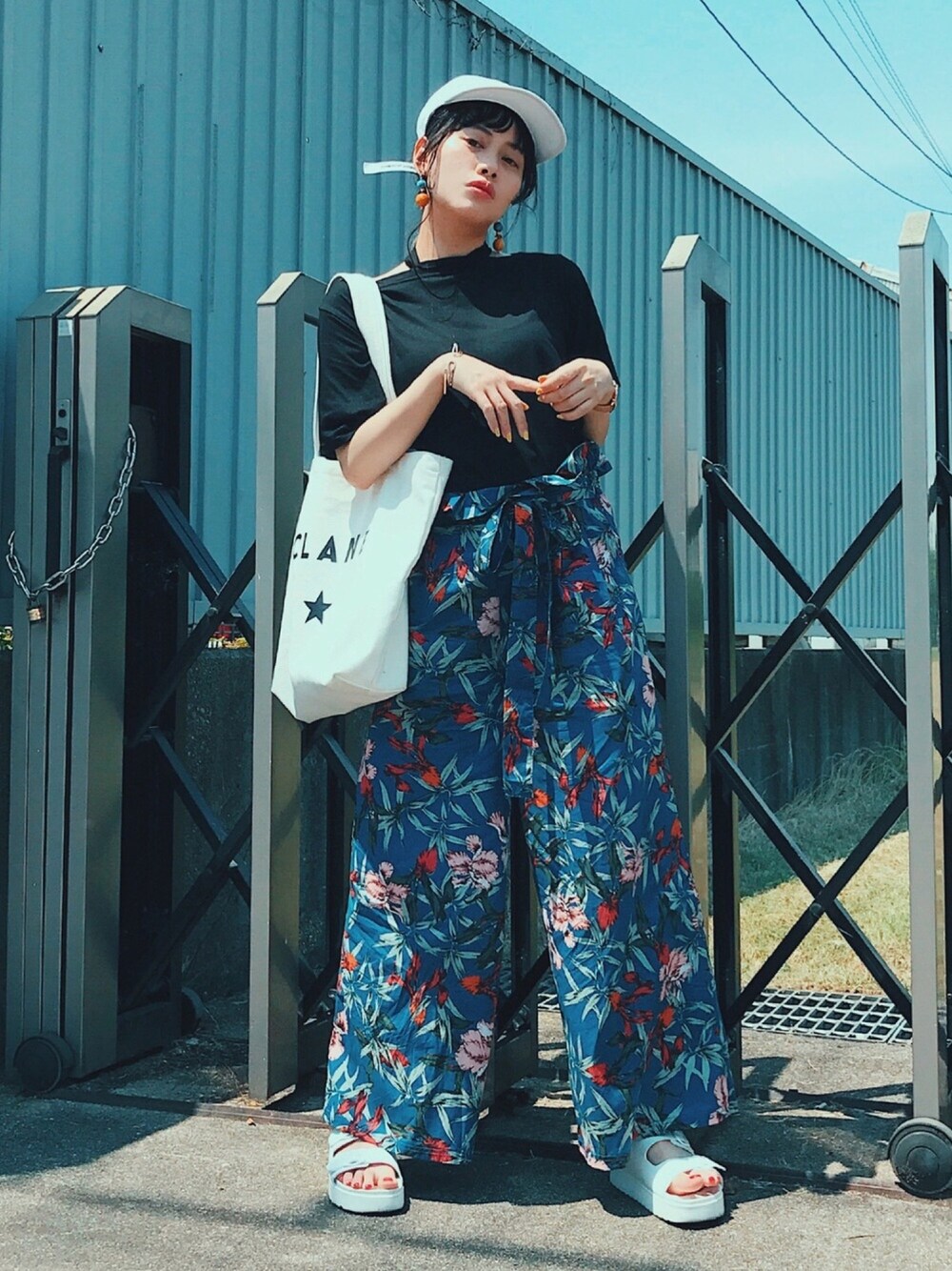 「カジュアルコーデ、夏、エコバッグ、白キャップ、花柄パンツ、ワイドパンツ、トートバッグ、サンダル、スポーツミックス、白」｜「KORMARCHのアイテム（トップス、ブラック系）」を使った、T Λ Eさん（レディース・158cm）の夏コーディネートの1枚目の写真