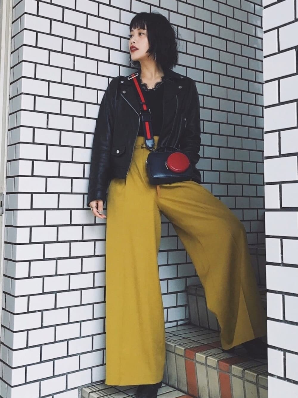 ブラック系のライダースジャケット、イエロー系のその他パンツ、その他のニット/セーターを着用したレディースの秋コーディネートの1枚目の写真