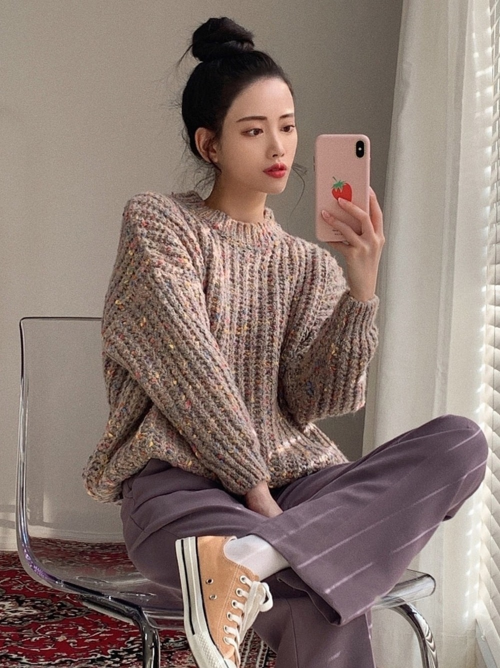 ピンク系のニット/セーター、パープル系のスラックス、イエロー系のスニーカーを着用したレディースの冬コーディネートの1枚目の写真