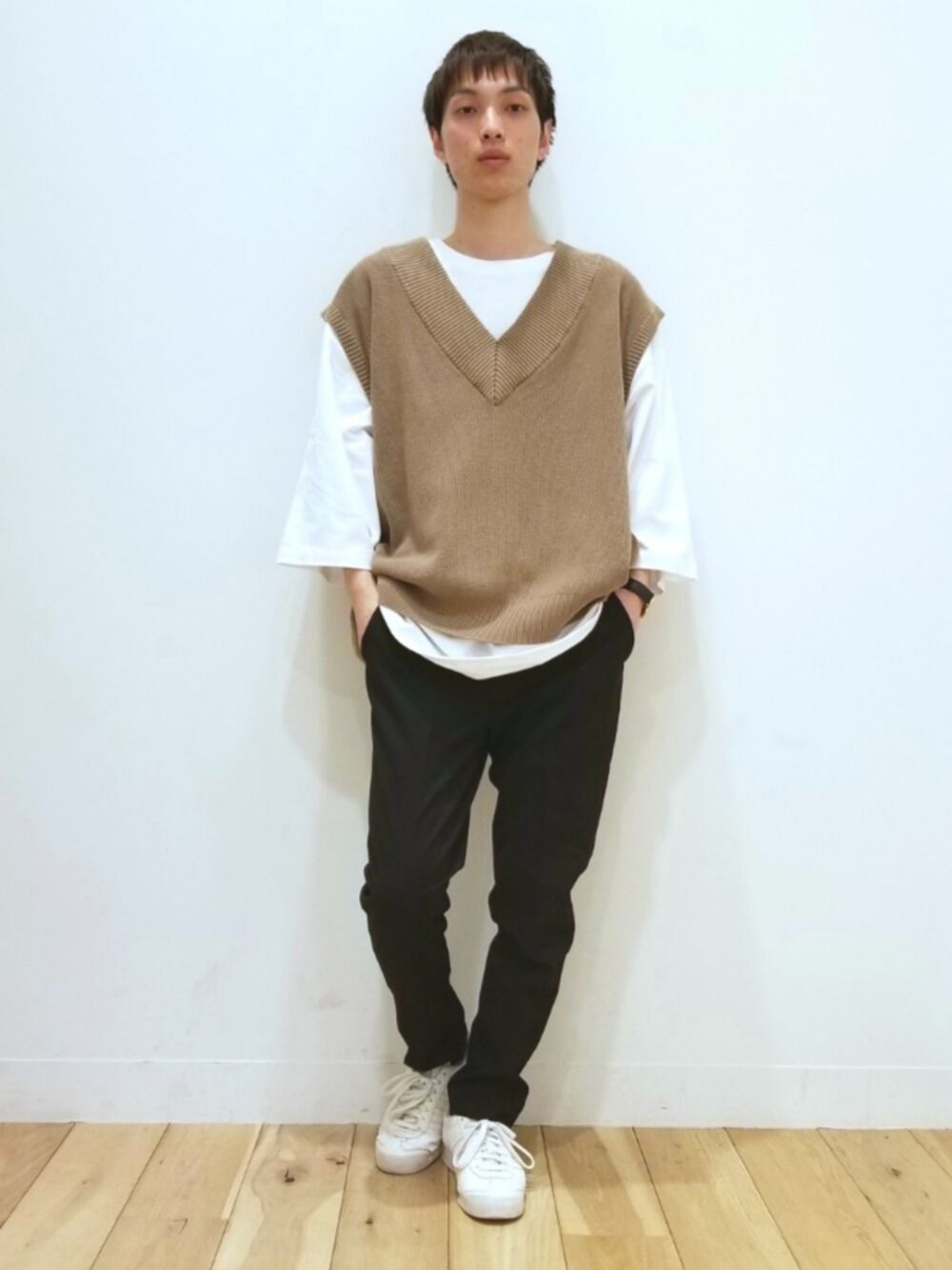 ブラック系のパンツ、ベージュ系のベスト、ホワイト系のTシャツ/カットソーを着用したメンズの春コーディネートの1枚目の写真