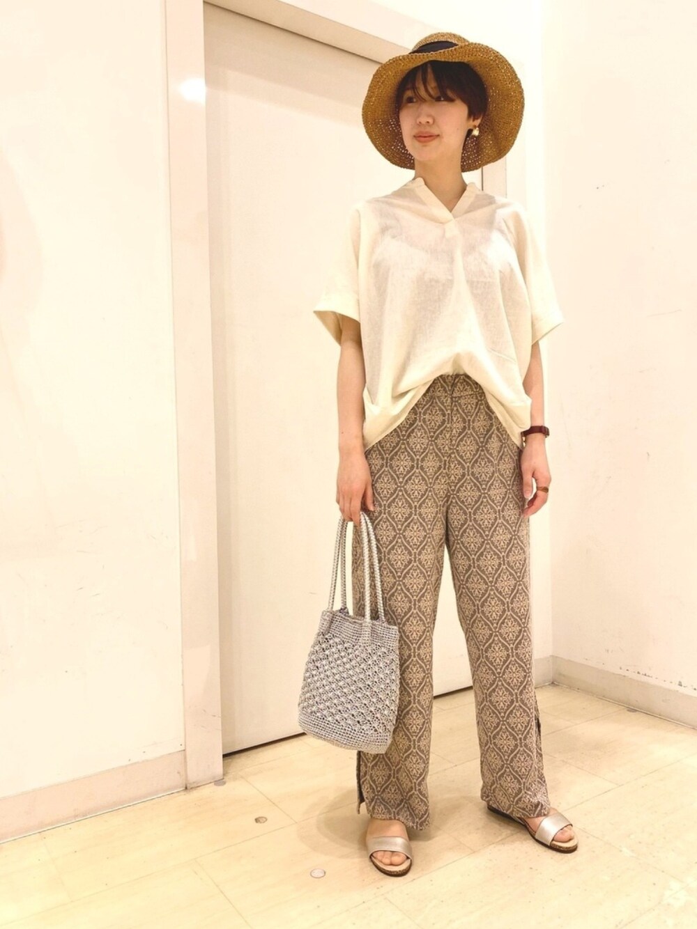ホワイト系のシャツ/ブラウス、グレー系のその他パンツ、ゴールド系のサンダルを着用したレディースの春コーディネートの1枚目の写真
