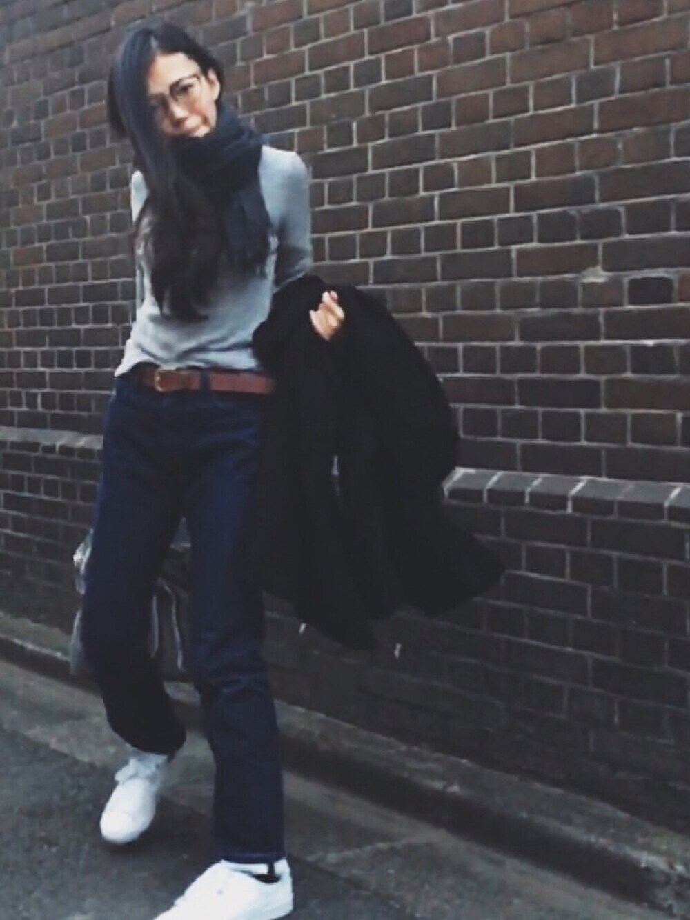 ホワイト系のスニーカー、ブラック系のダッフルコート、ブルー系のデニムパンツを着用したレディースの春コーディネートの1枚目の写真