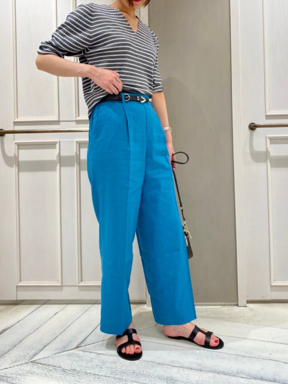 ブルー系のその他パンツ、その他のニット/セーター、ブラック系のショルダーバッグを着用したレディースの夏コーディネートの1枚目の写真