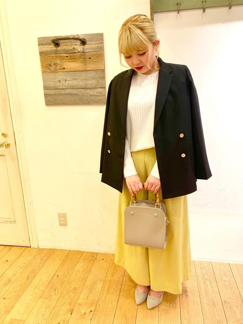 グレー系のハンドバッグ、イエロー系のその他パンツ、グレー系のパンプスを着用したレディースの春コーディネートの1枚目の写真