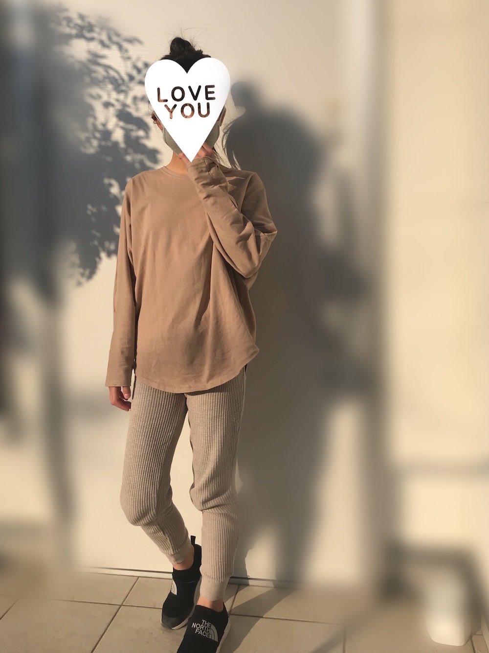 ベージュ系のトップス、ベージュ系のパンツ、ブラック系のスニーカーを着用したキッズの春コーディネートの1枚目の写真