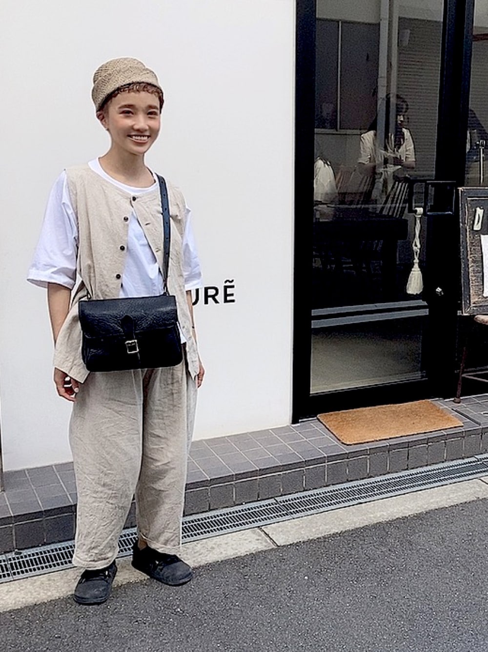 ブラック系のバッグ、ホワイト系のTシャツ/カットソーを着用したレディースの夏コーディネートの1枚目の写真