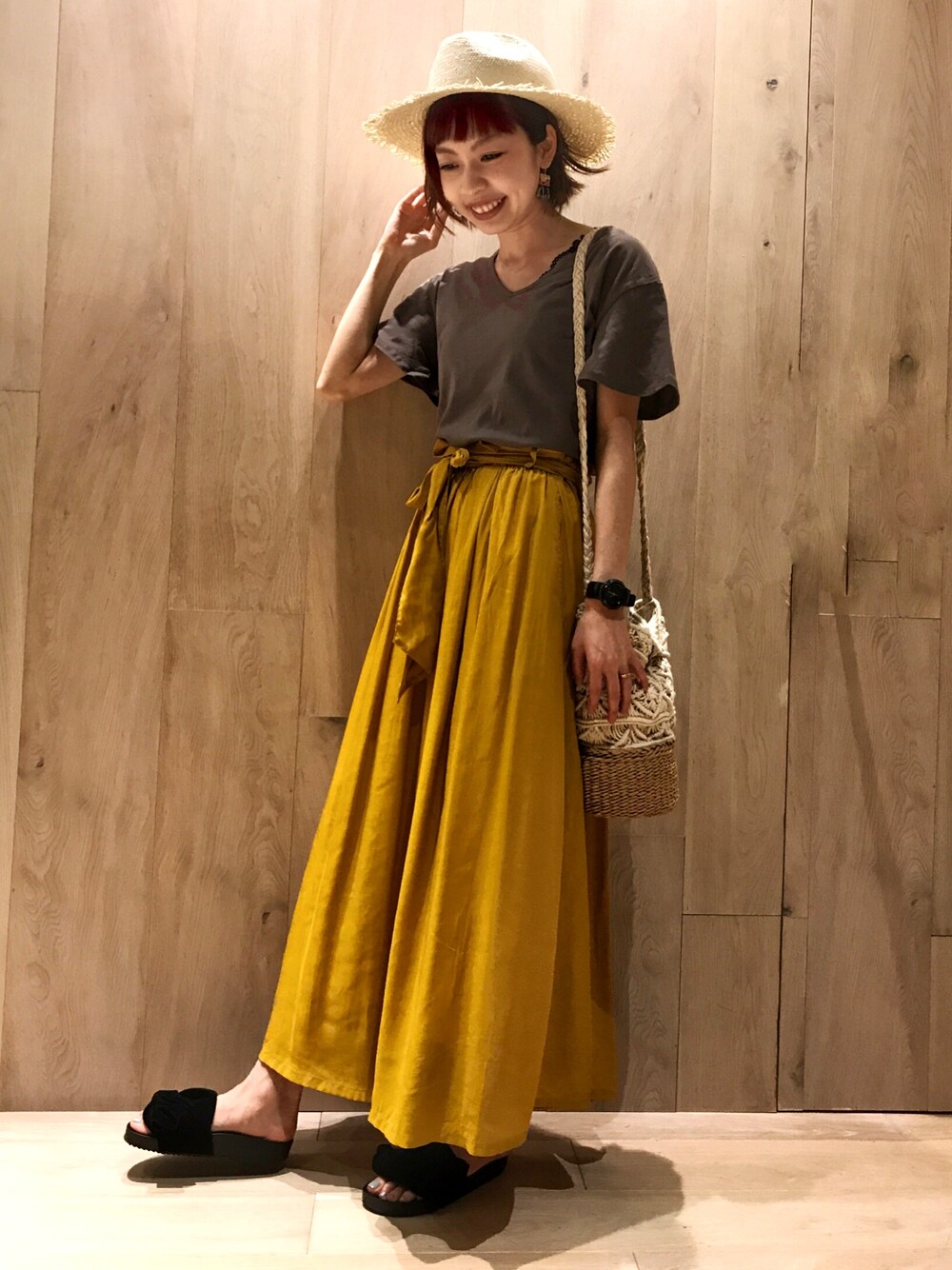 ブラック系のタンクトップ、ブラウン系のTシャツ/カットソー、イエロー系のスカートを着用したレディースの春コーディネートの1枚目の写真