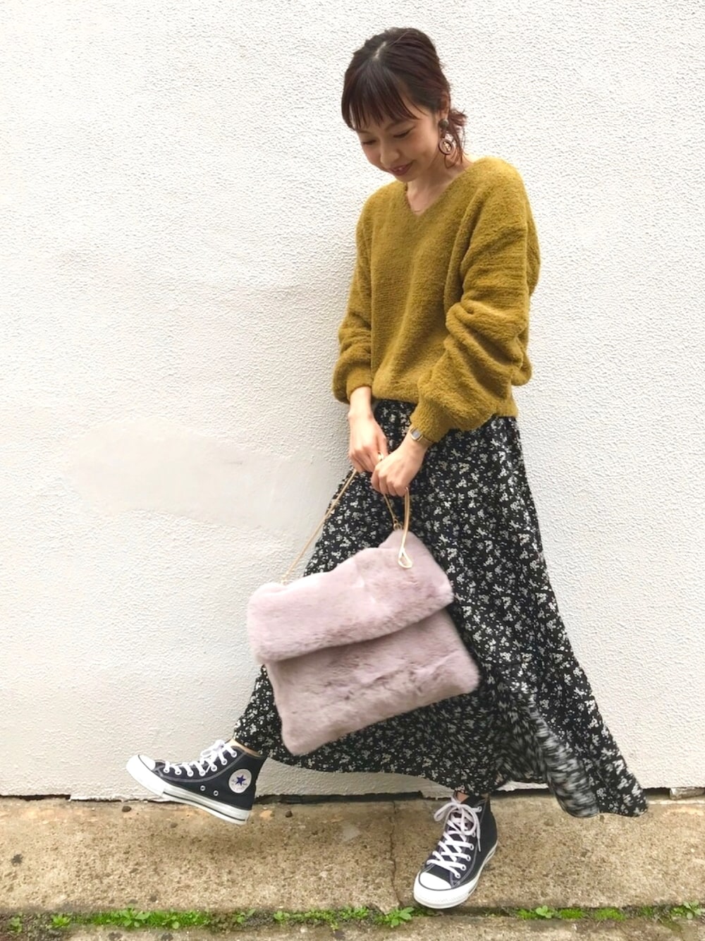 グリーン系のニット/セーター、ブラック系のスカート、グレー系のショルダーバッグを着用したレディースの冬コーディネートの1枚目の写真