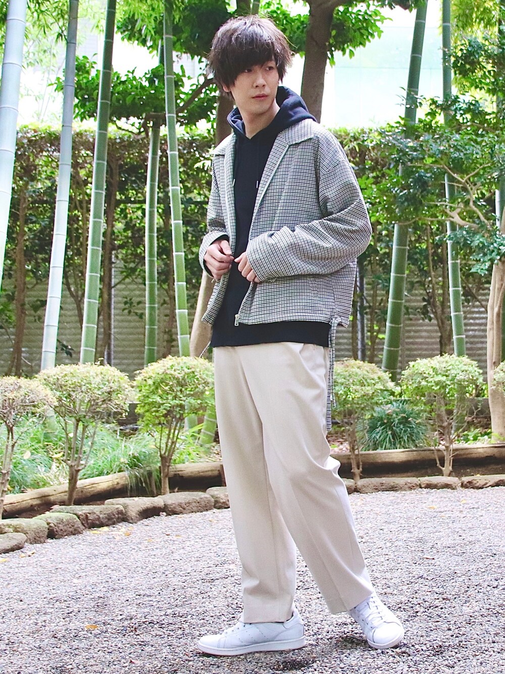 ベージュ系のブルゾン、ブラック系のパーカー、ホワイト系のスラックスを着用したメンズの秋コーディネートの1枚目の写真