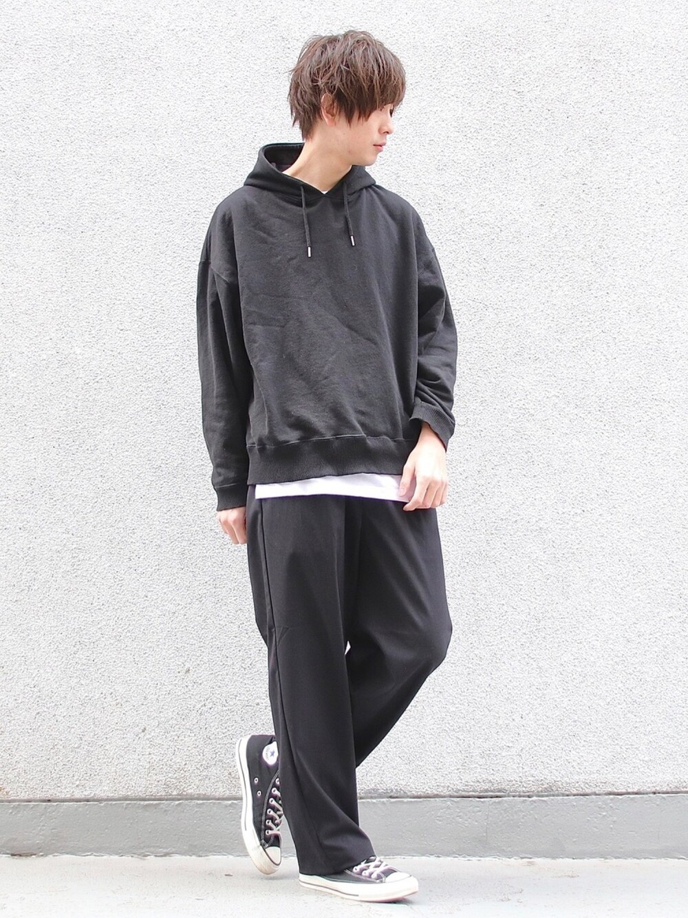 ブラック系のパーカー、ブラック系のスラックス、ホワイト系のTシャツ/カットソーを着用したメンズの冬コーディネートの1枚目の写真