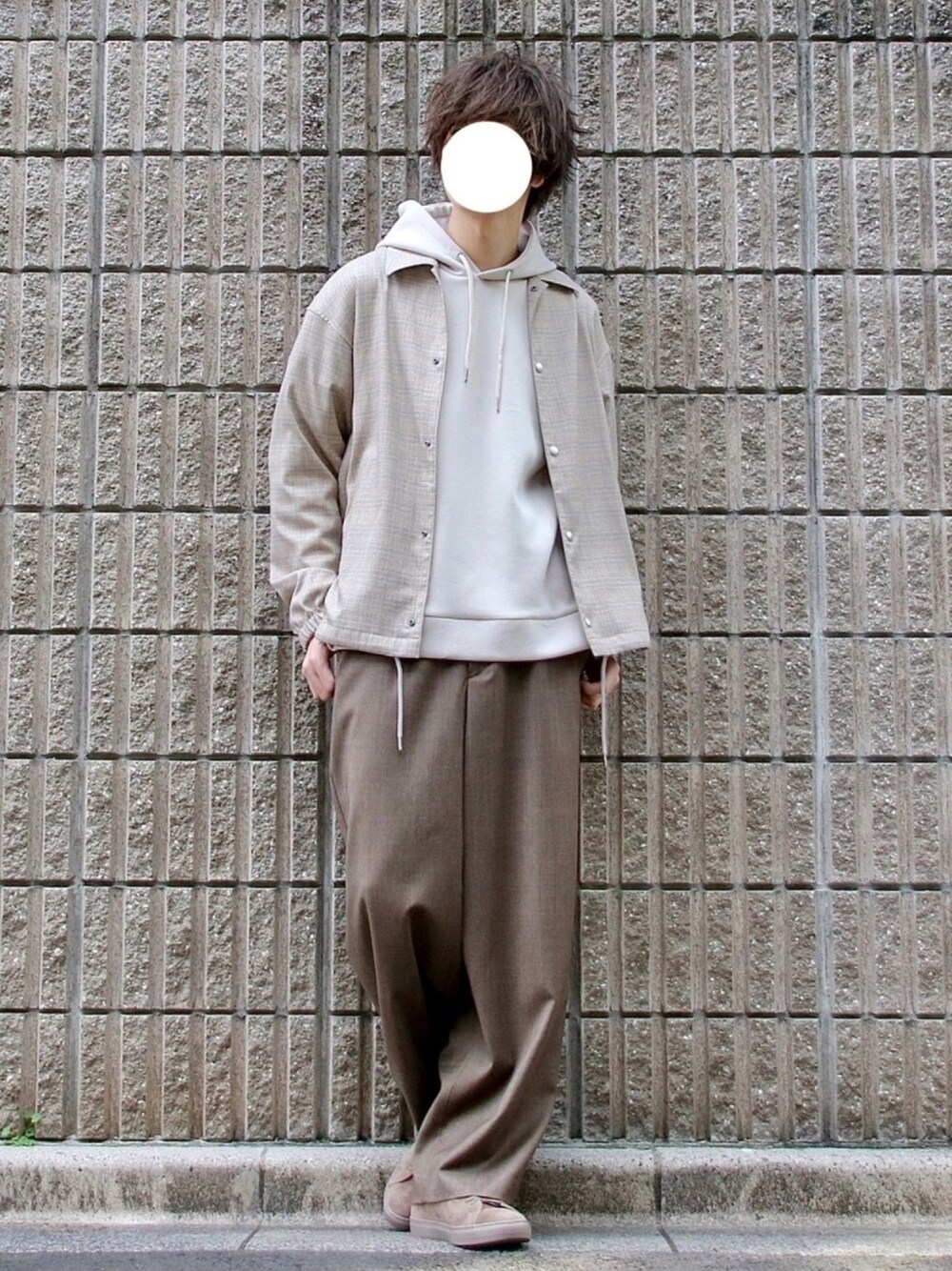 ベージュ系のブルゾン、ホワイト系のパーカー、ブラウン系のスラックスを着用したメンズの春コーディネートの1枚目の写真