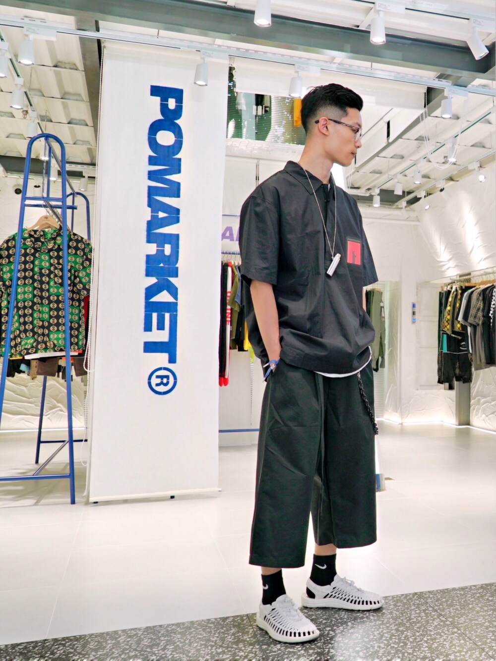 ブラック系のシャツ/ブラウス、ブラック系のカーゴパンツ、ホワイト系のサンダルを着用したメンズの夏コーディネートの1枚目の写真