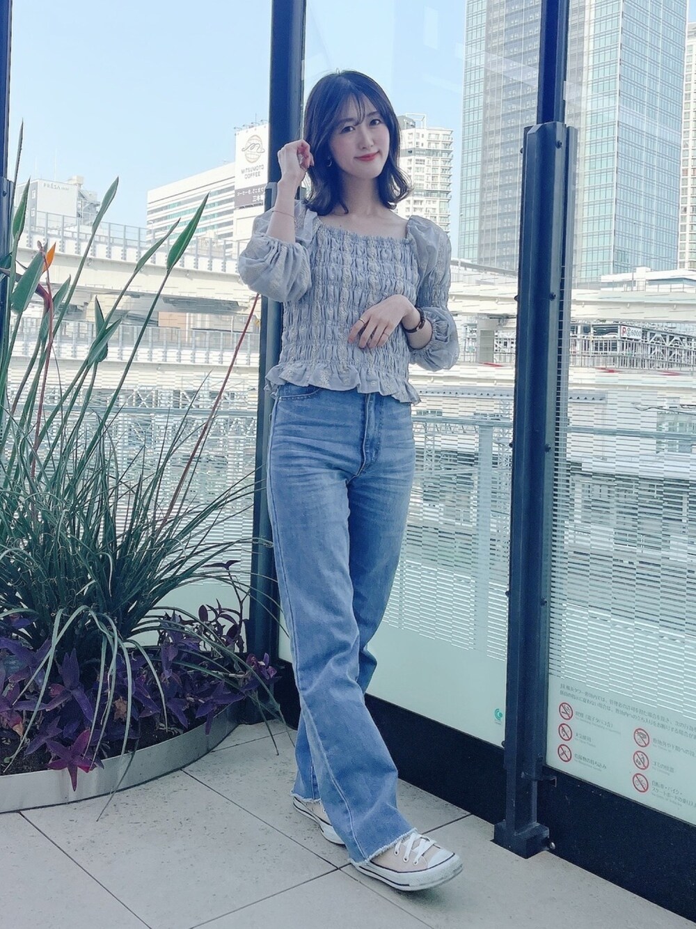 ブルー系のデニムパンツ、グリーン系のシャツ/ブラウス、ベージュ系のスニーカーを着用したレディースの春コーディネートの1枚目の写真