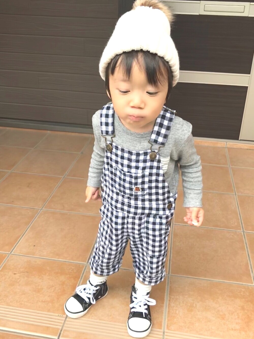 ブラック系のサロペット/オーバーオール、グレー系のその他トップス、ブラック系のスニーカーを着用したキッズの秋コーディネートの1枚目の写真