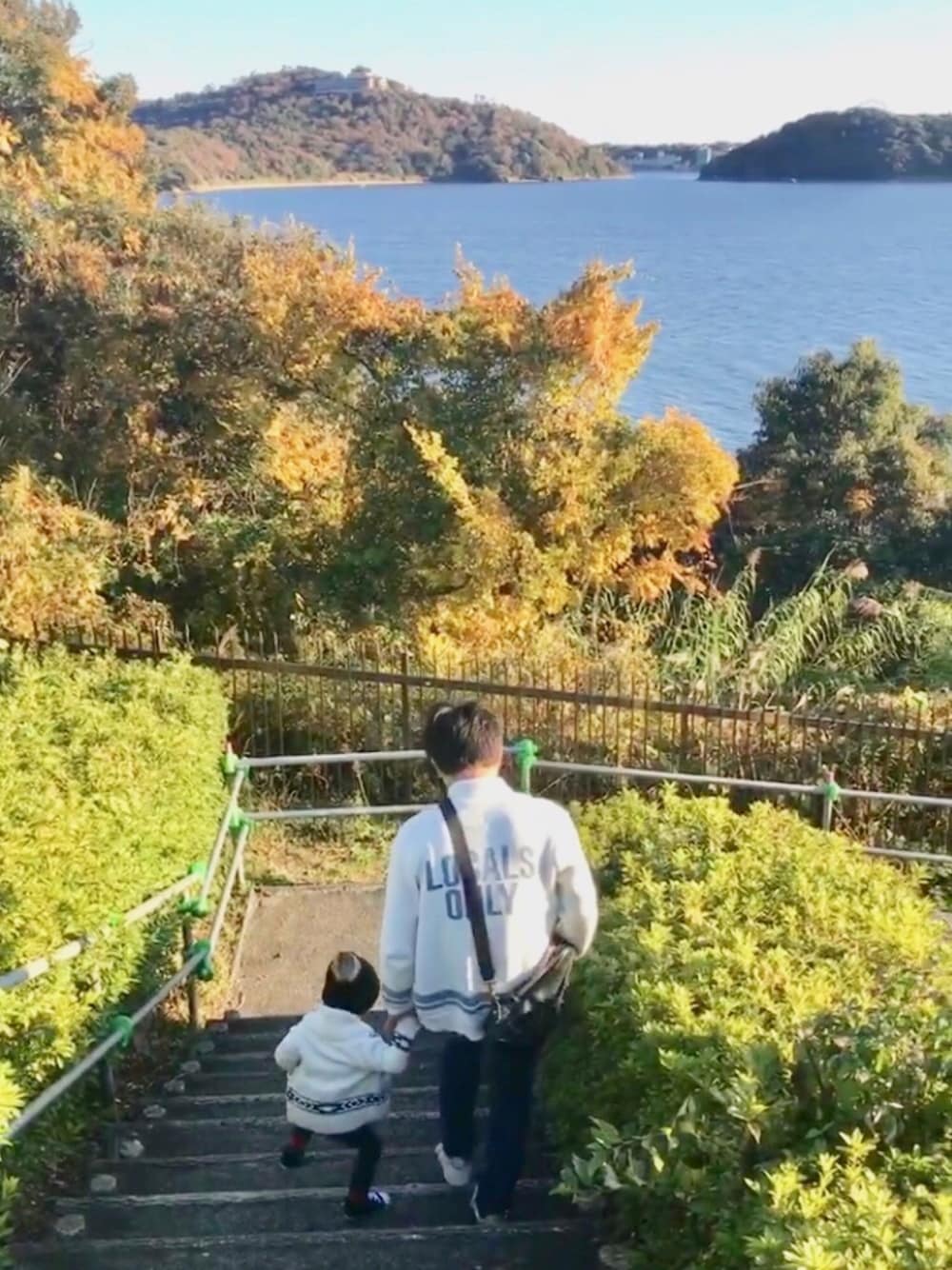 ホワイト系のカーディガン/ボレロ、ブルー系のデニムパンツ、ブラック系のスニーカーを着用したキッズの冬コーディネートの1枚目の写真