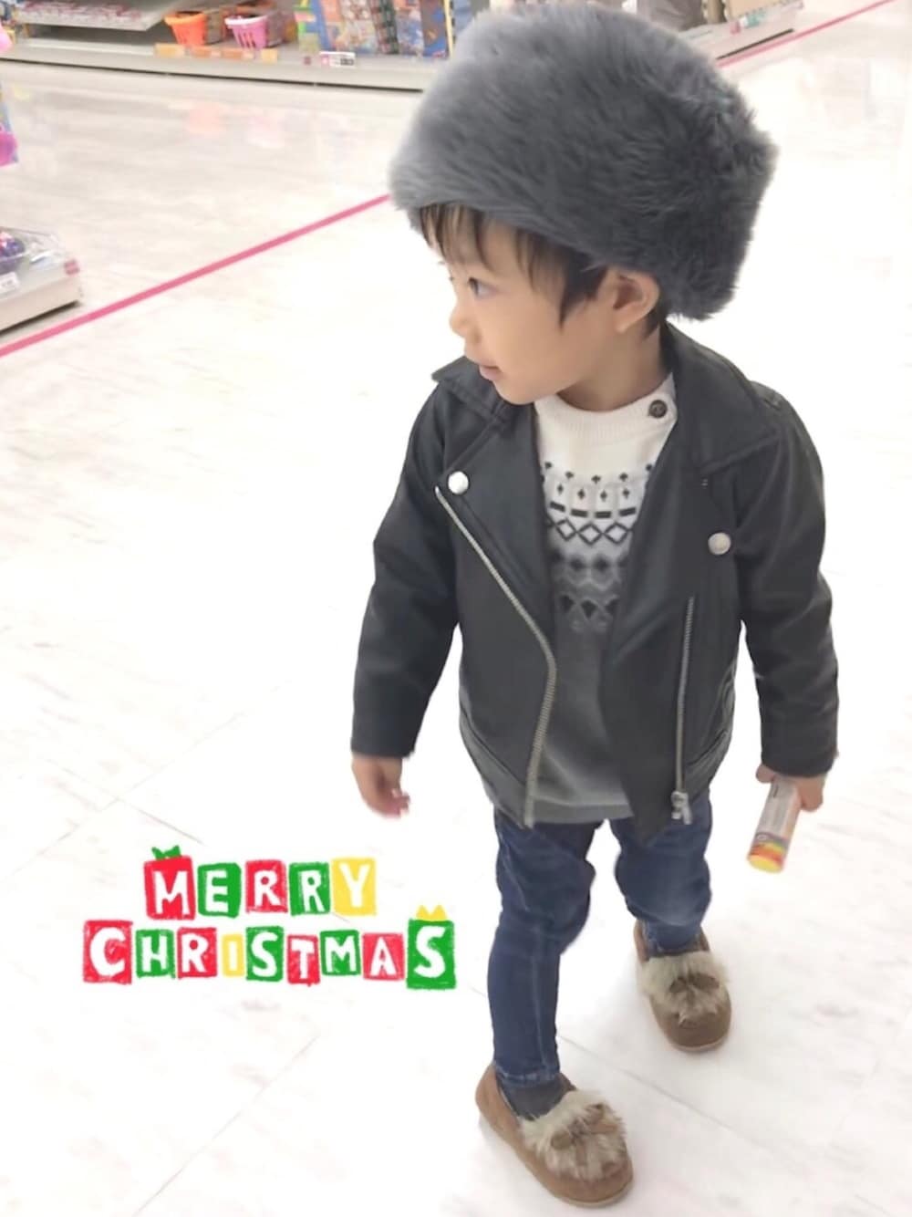 ブラック系のライダースジャケット、グレー系のニット/セーター、ブルー系のデニムパンツを着用したキッズの冬コーディネートの1枚目の写真