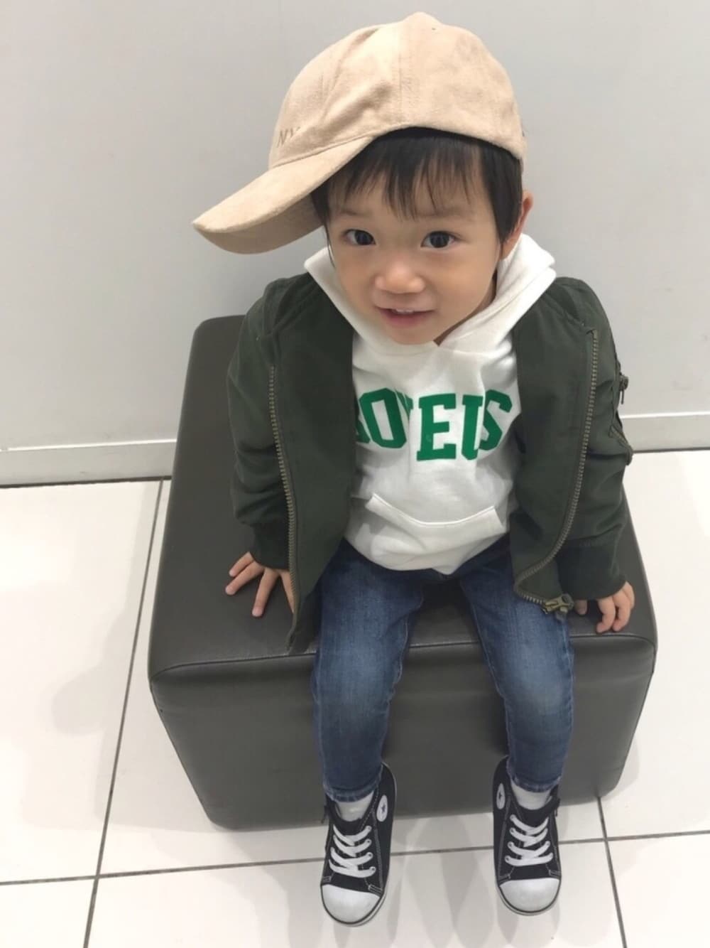 グリーン系のMA-1、ホワイト系のパーカー、ブルー系のデニムパンツを着用したキッズの冬コーディネートの1枚目の写真