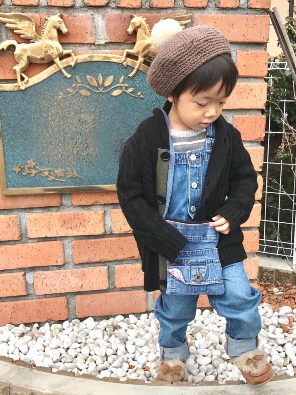 ブラック系のカーディガン/ボレロ、グレー系のニット/セーター、ブルー系のサロペット/オーバーオールを着用したキッズの冬コーディネートの1枚目の写真