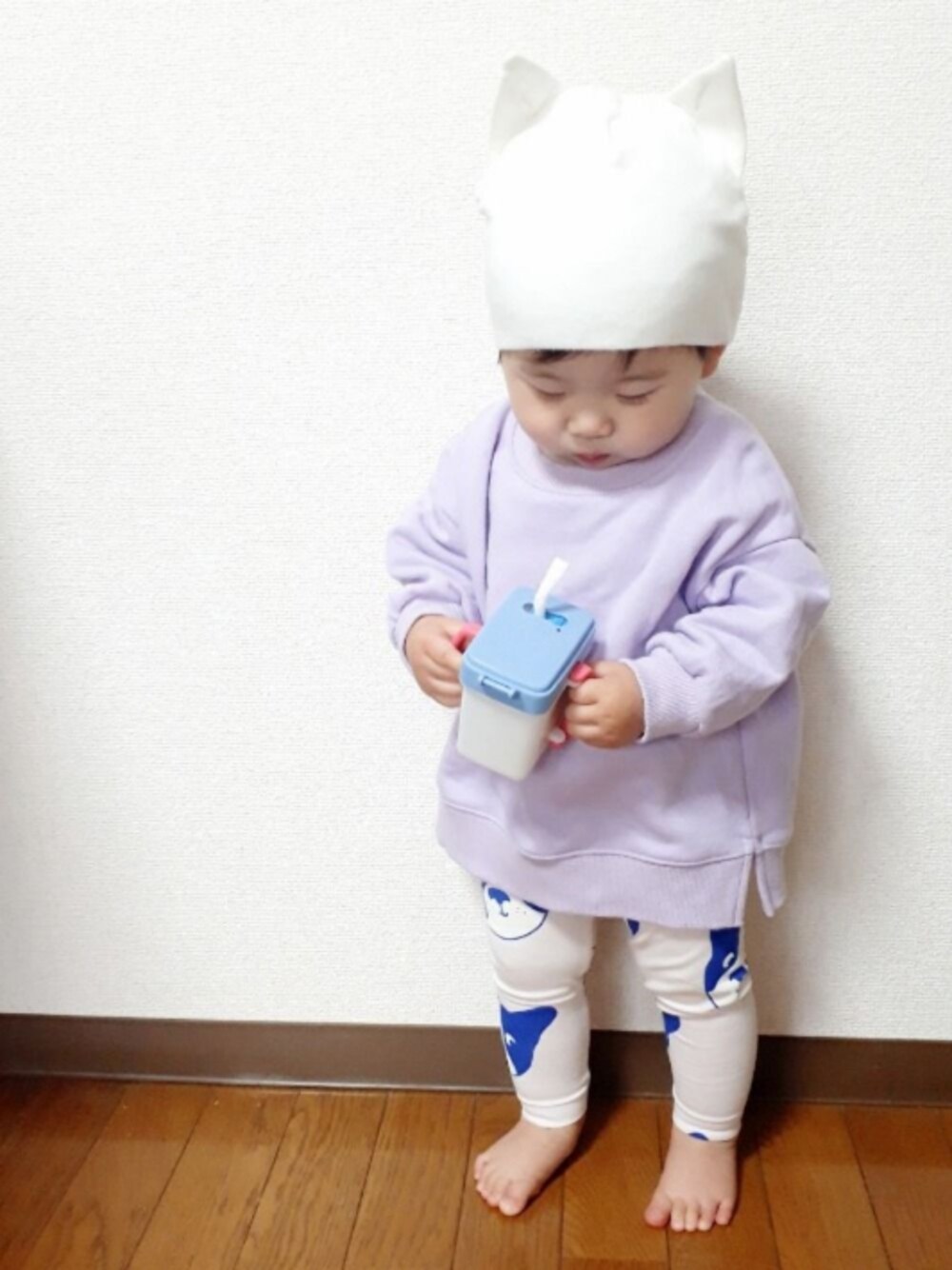 パープル系のスウェット、ピンク系のレギンス/スパッツ、ホワイト系のニットキャップ/ビーニーを着用したキッズの春コーディネートの1枚目の写真