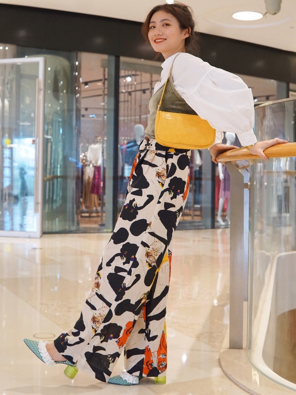 イエロー系のバッグ、その他のパンツ、グリーン系のシューズを着用したレディースの春コーディネートの1枚目の写真
