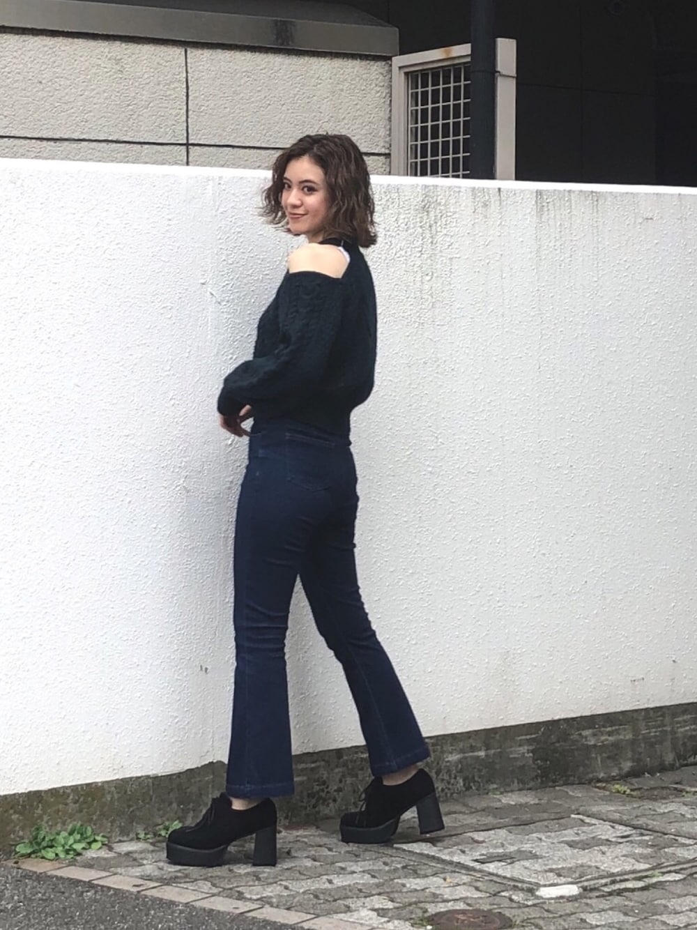 グリーン系のニット/セーター、ブルー系のデニムパンツ、ブラック系のその他シューズを着用したレディースの秋コーディネートの1枚目の写真