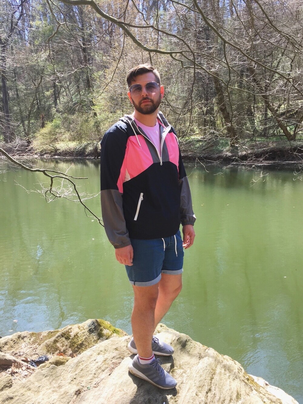 ピンク系のナイロンジャケット、ブルー系のデニムパンツ、グレー系のスニーカーを着用したメンズの春コーディネートの1枚目の写真