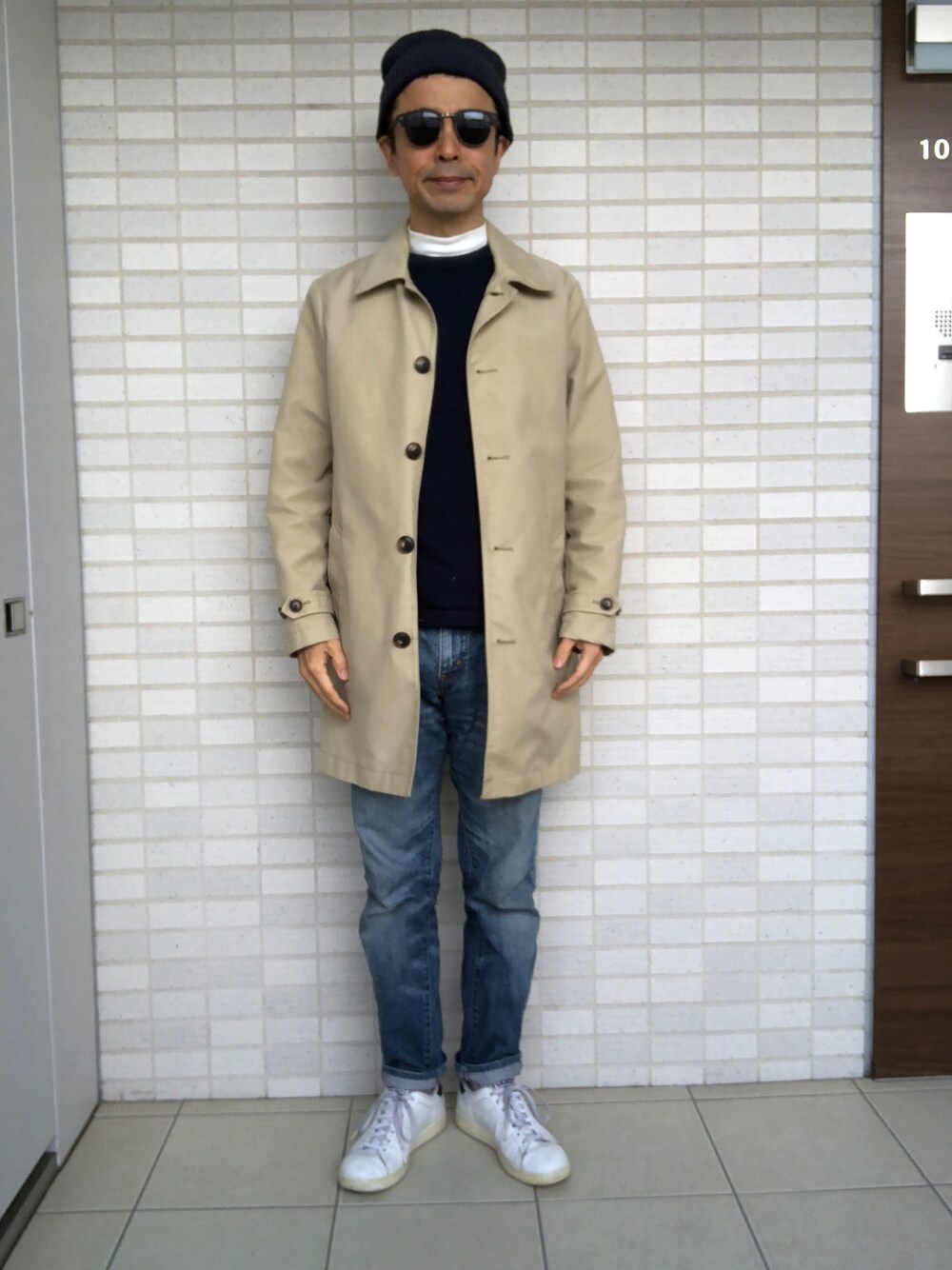 「秋のコーデ、デニムパンツ、ステンカラーコート、白スニーカー、ニット帽、サングラス」｜「GAPのアイテム（ステンカラーコート、ベージュ系）」を使った、Paulさん（メンズ・171cm）の秋コーディネートの1枚目の写真