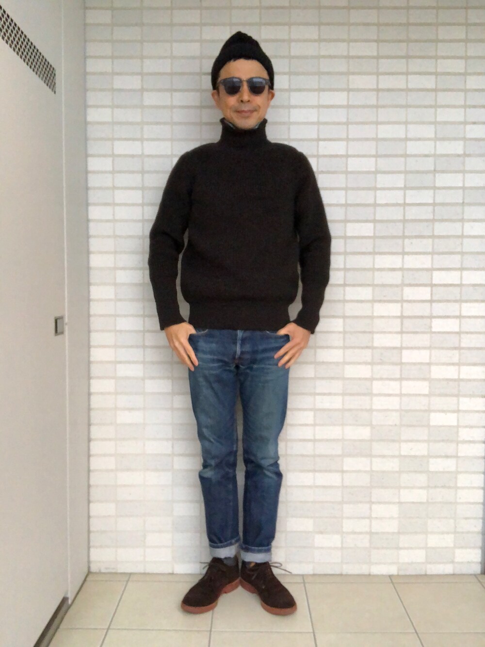 「ローゲージニット、ハイネック、デニムパンツ、スエードシューズ、ニット帽、ネイビー×ブラウン、ブラウン×ネイビー」｜「BATONERの＜BATONER（バトナー）＞ AZE BIAS TTL（ニット/セーター、ブラウン系）」を使った、Paulさん（メンズ・171cm）の冬コーディネートの1枚目の写真