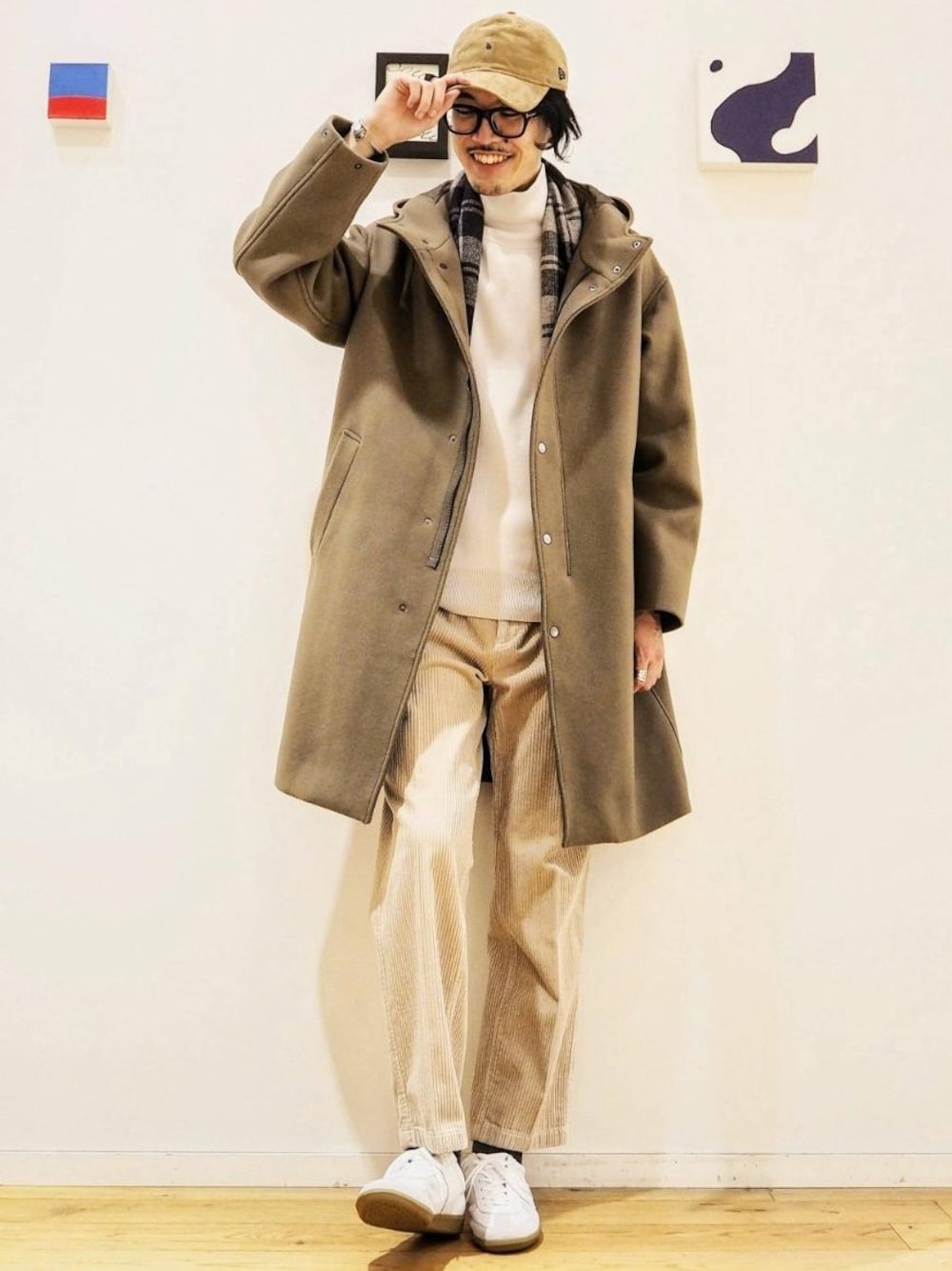 ホワイト系のスニーカー、ベージュ系のその他アウター、ベージュ系のニット/セーターを着用したメンズの秋コーディネートの1枚目の写真