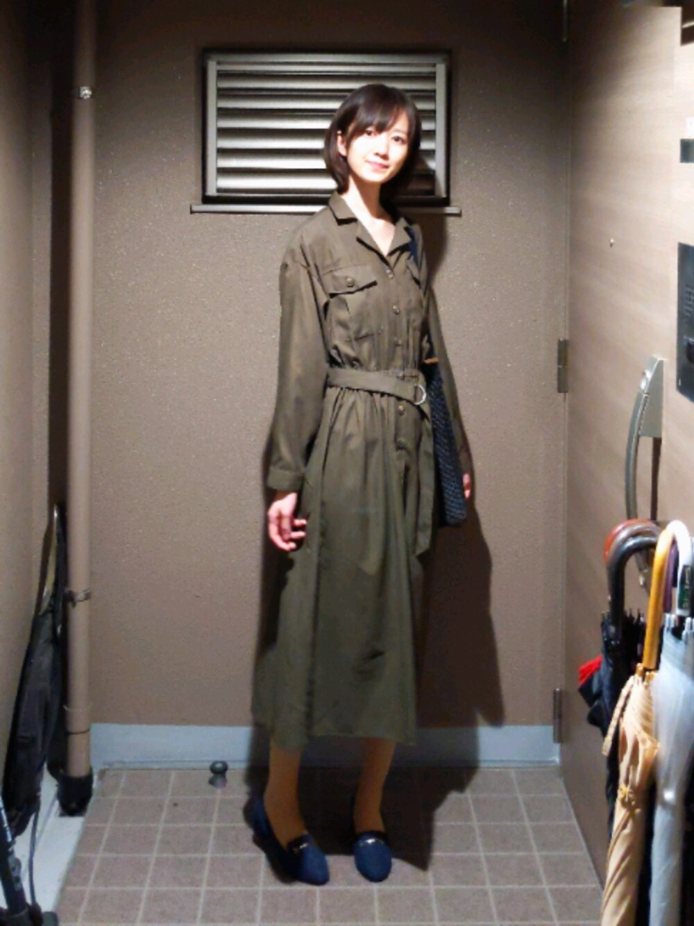 グリーン系のワンピース/ドレス、ブルー系のパンプス、ブラック系のかごバッグを着用したレディースの秋コーディネートの1枚目の写真