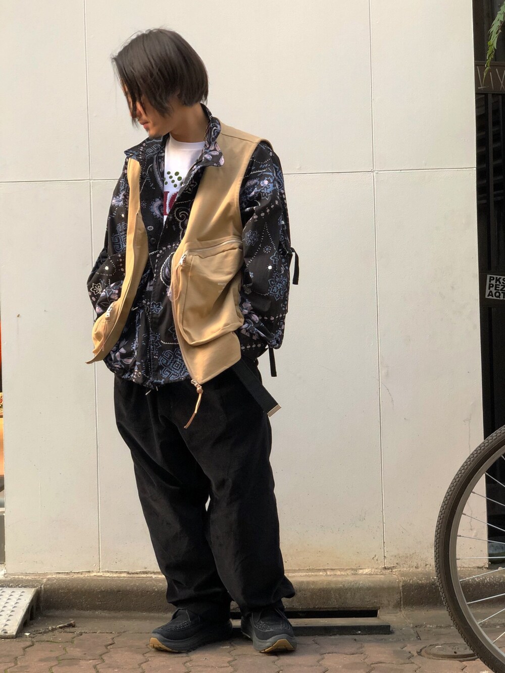 ベージュ系のベストを着用したメンズの春コーディネートの1枚目の写真