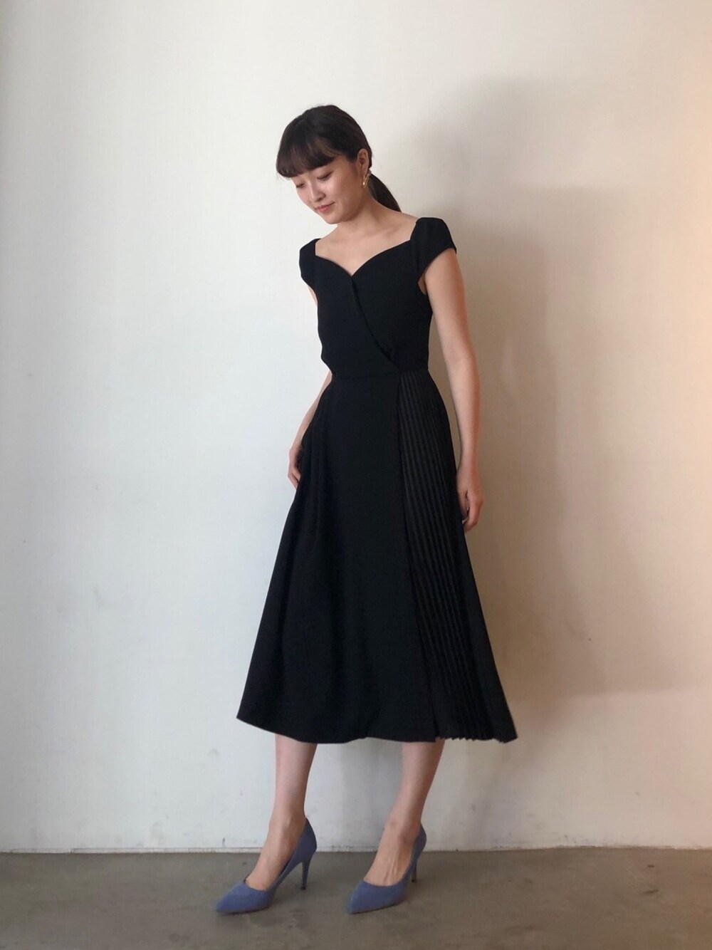 ブラック系のドレスを着用したレディースの春コーディネートの1枚目の写真