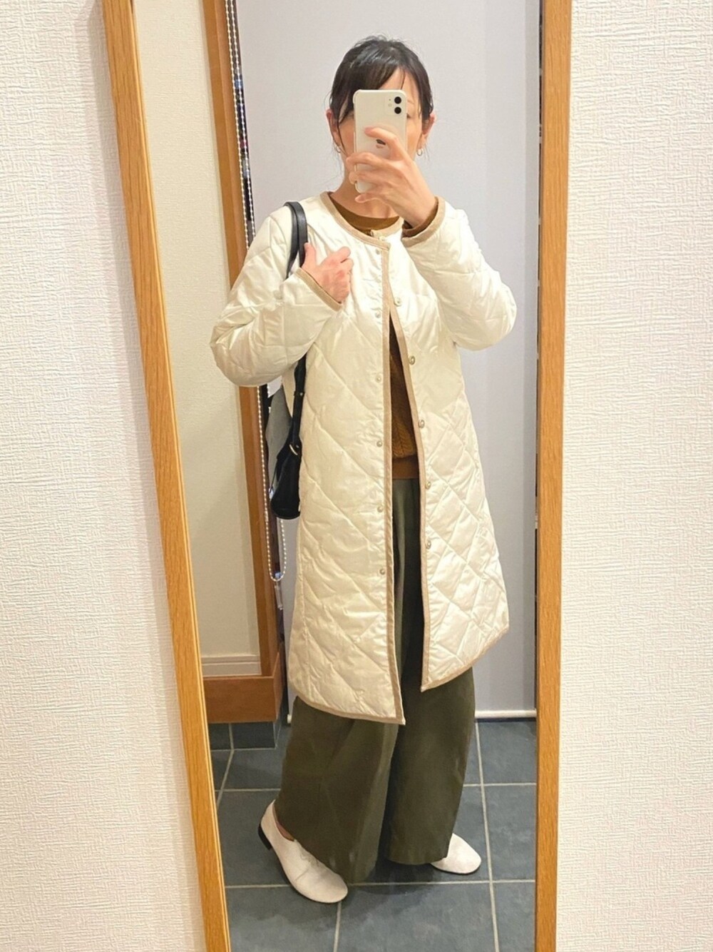 ホワイト系のジャケット/アウター、イエロー系のニット/セーター、ブラック系のショルダーバッグを着用したレディースの冬コーディネートの1枚目の写真