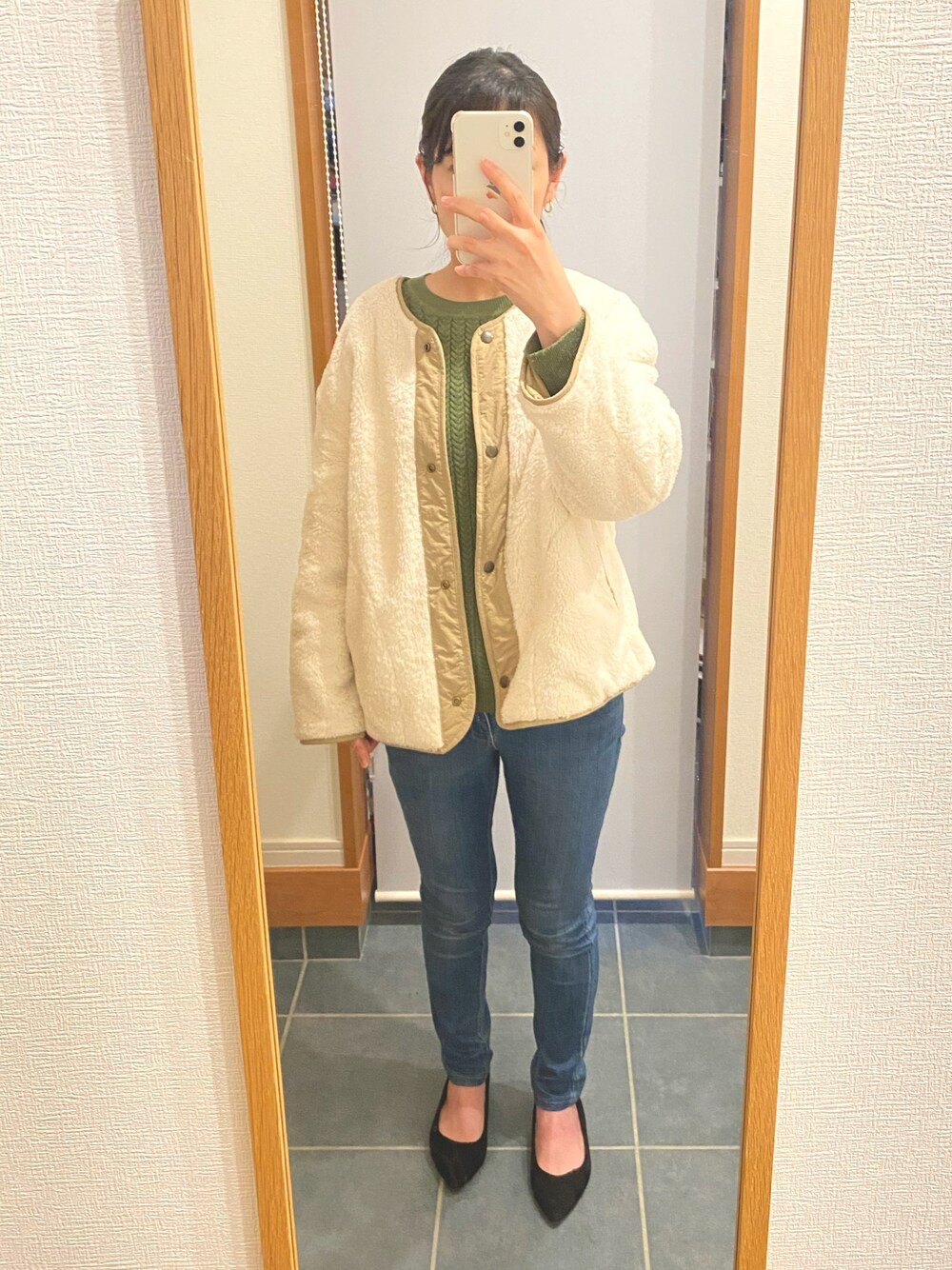 ベージュ系のジャケット/アウター、ブルー系のデニムパンツ、グリーン系のニット/セーターを着用したレディースの春コーディネートの1枚目の写真