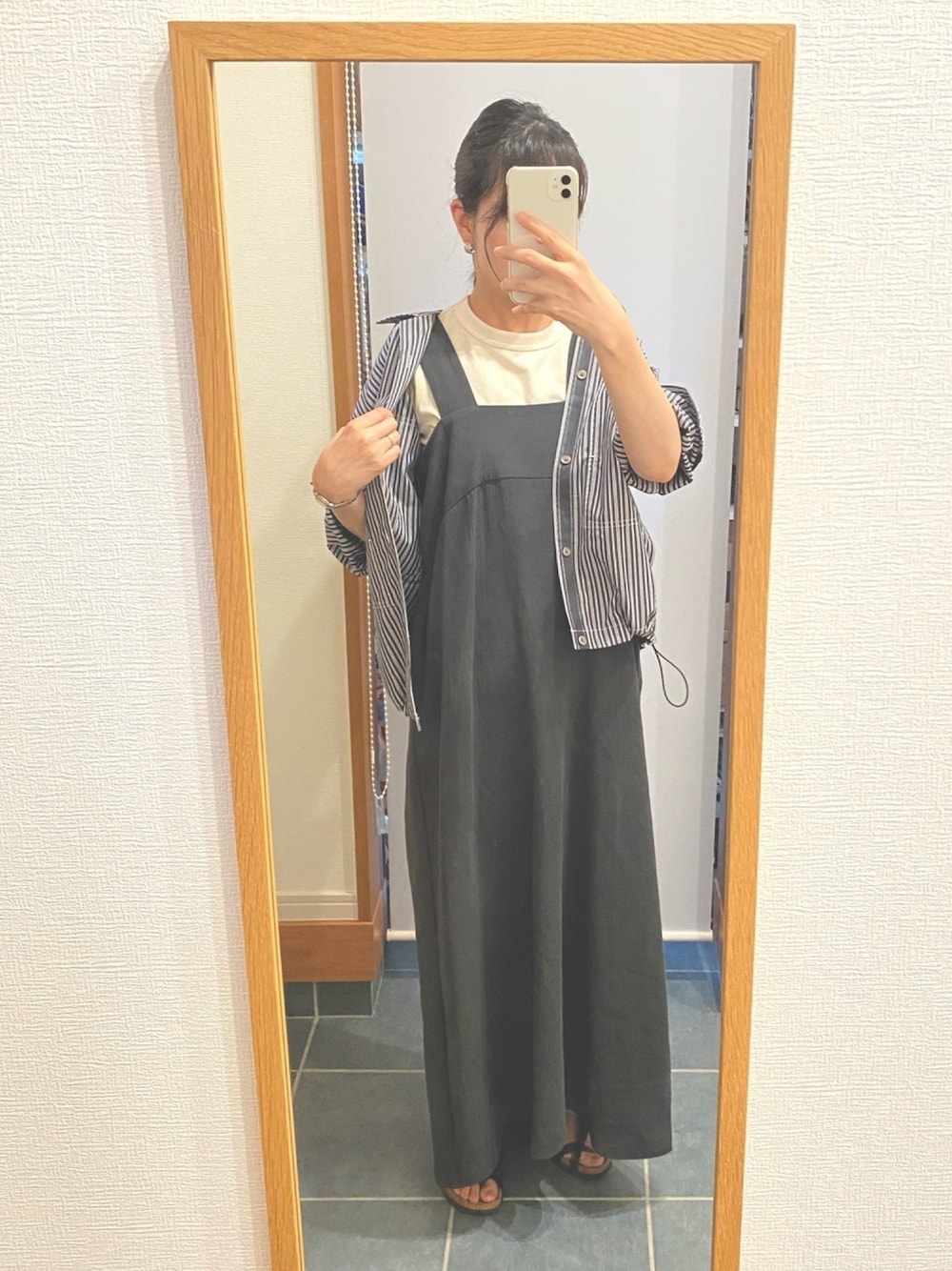 グレー系のワンピース、グレー系のシャツ/ブラウス、ブラック系のサンダルを着用したレディースの春コーディネートの1枚目の写真