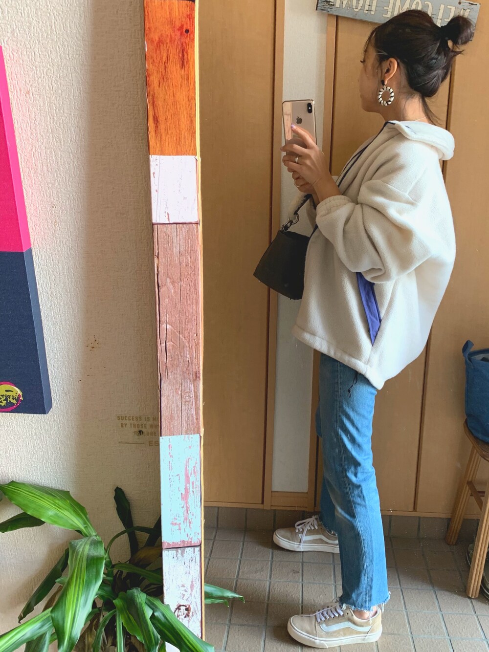 ベージュ系のブルゾン、ブルー系のデニムパンツ、グレー系のハンドバッグを着用したレディースの秋コーディネートの1枚目の写真