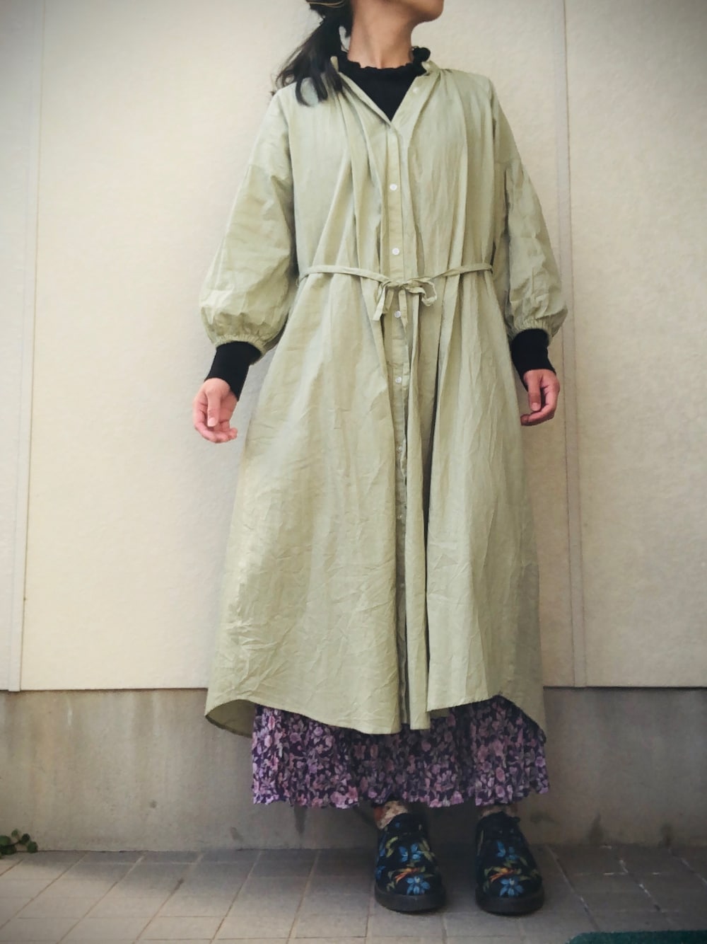 グリーン系のシャツワンピース、パープル系のスカート、その他のシューズを着用したレディースの冬コーディネートの1枚目の写真