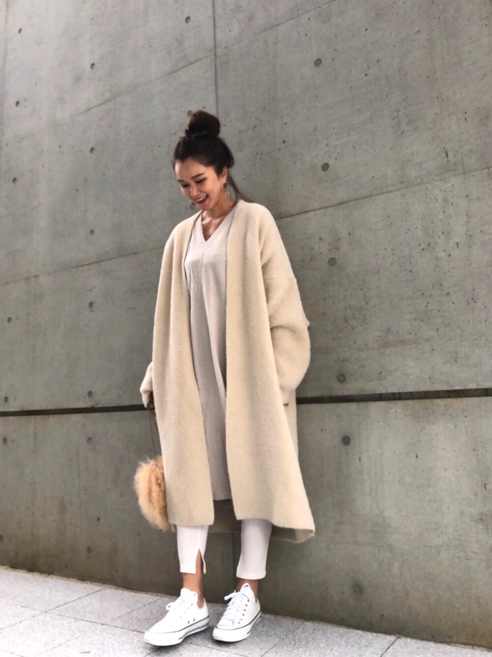ベージュ系のワンピース、ベージュ系のその他アウター、ホワイト系のスニーカーを着用したレディースの冬コーディネートの1枚目の写真