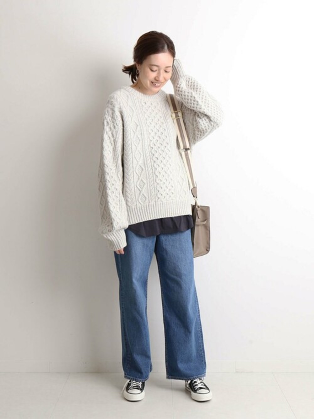 グレー系のニット/セーター、ブラック系のタンクトップ、ベージュ系のショルダーバッグを着用したレディースの夏コーディネートの1枚目の写真