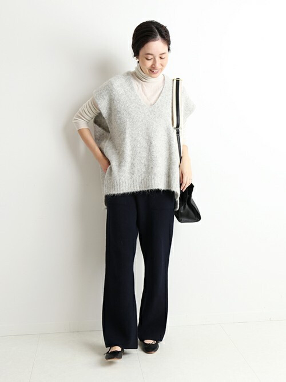 グレー系のベスト、ブルー系のその他パンツ、ベージュ系のTシャツ/カットソーを着用したレディースの冬コーディネートの1枚目の写真