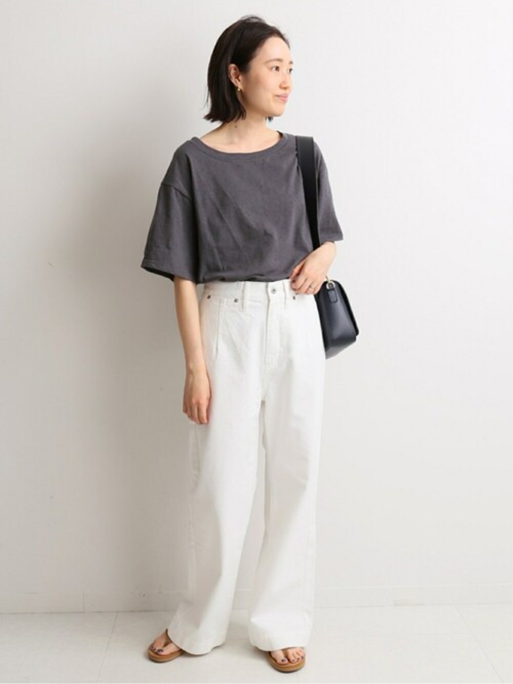 グレー系のTシャツ/カットソー、ホワイト系のデニムパンツ、ブルー系のショルダーバッグを着用したレディースの春コーディネートの1枚目の写真