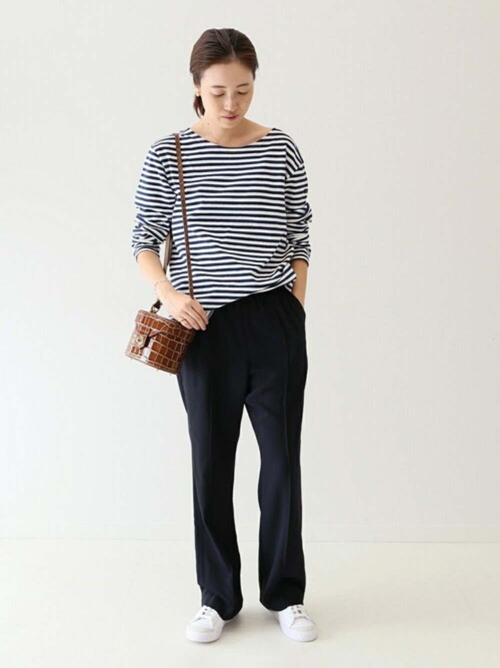 ブラック系のその他パンツ、ブルー系のTシャツ/カットソー、ブラウン系のハンドバッグを着用したレディースの秋コーディネートの1枚目の写真