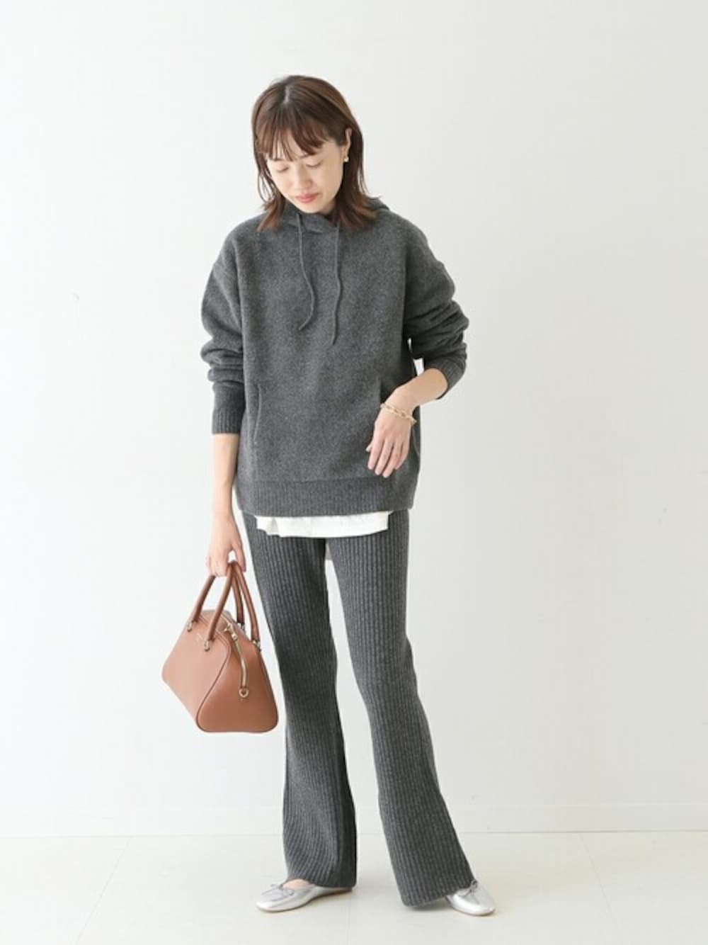 グレー系のニット/セーター、グレー系のその他パンツ、イエロー系のボストンバッグを着用したレディースの秋コーディネートの1枚目の写真