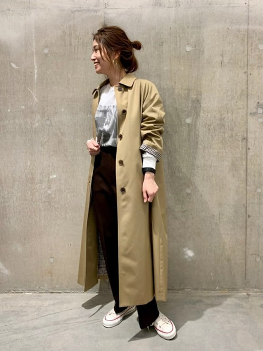 ベージュ系のステンカラーコート、ホワイト系のTシャツ/カットソー、ブラウン系のその他パンツを着用したレディースの冬コーディネートの1枚目の写真