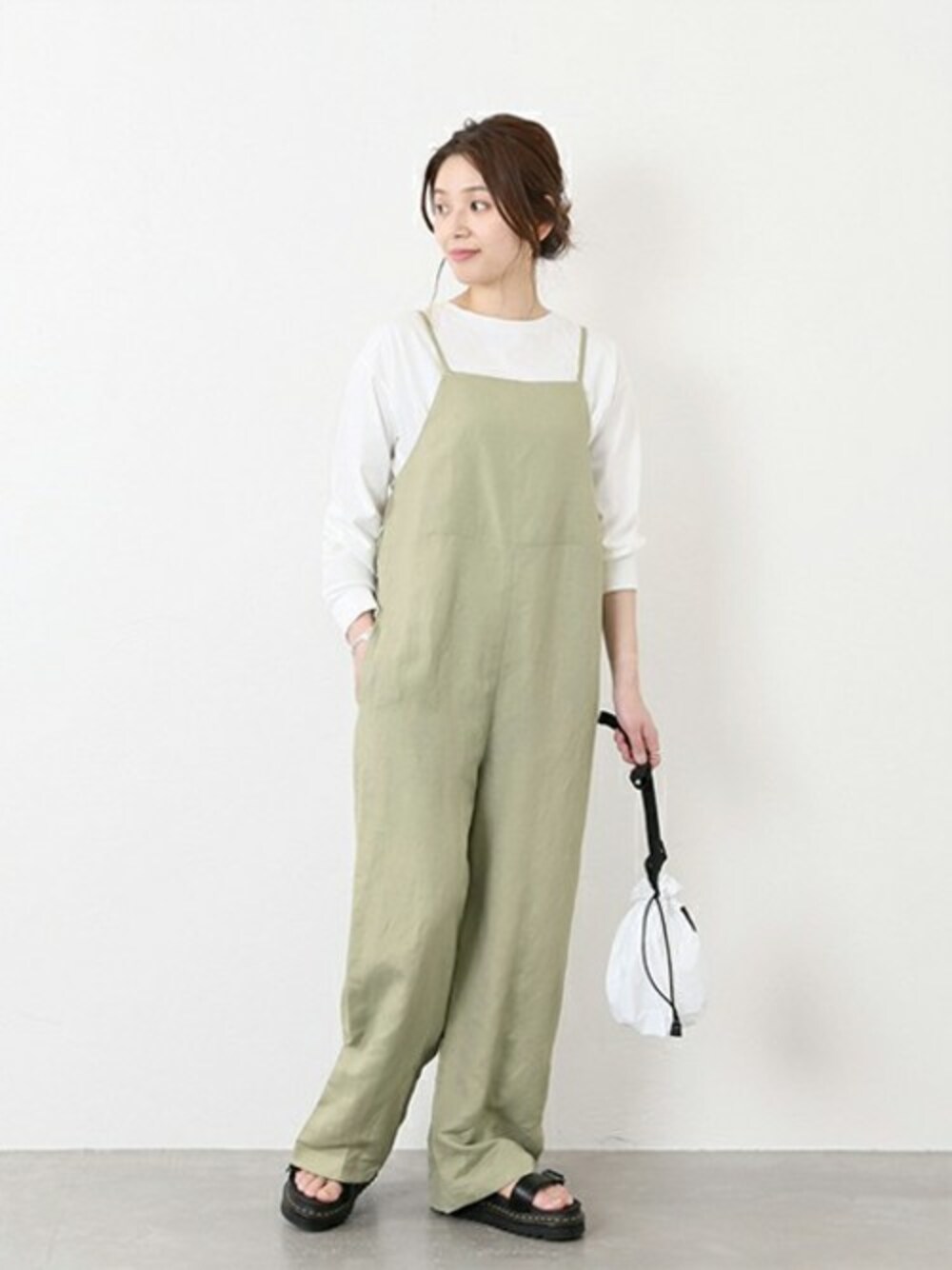 グリーン系のサロペット/オーバーオール、ホワイト系のTシャツ/カットソーを着用したレディースの冬コーディネートの1枚目の写真