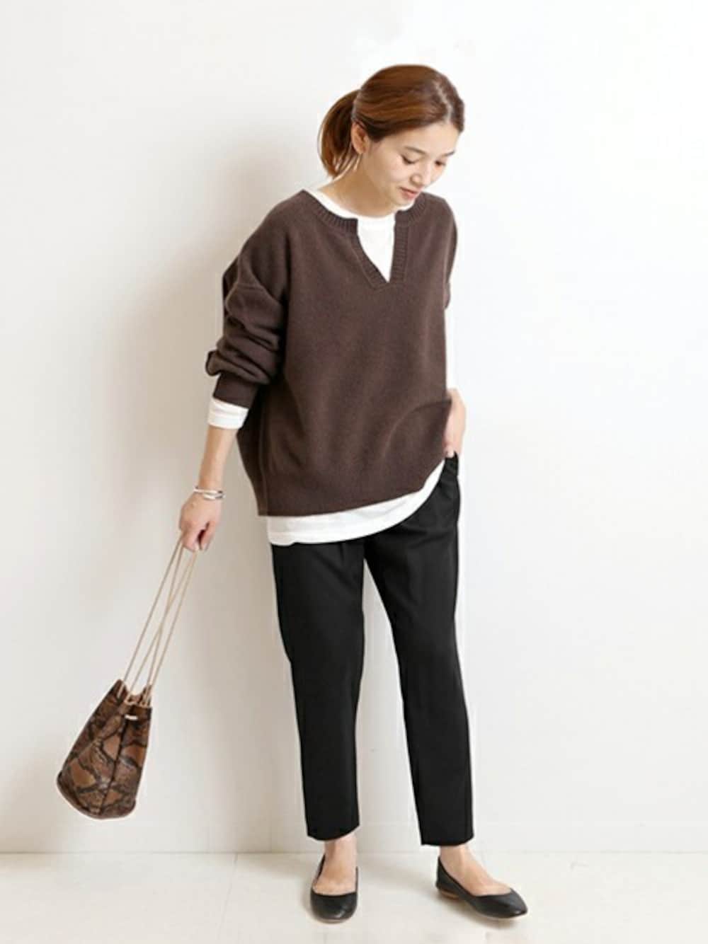 ブラック系のその他パンツ、ブラウン系のニット/セーター、ブラウン系のショルダーバッグを着用したレディースの秋コーディネートの1枚目の写真