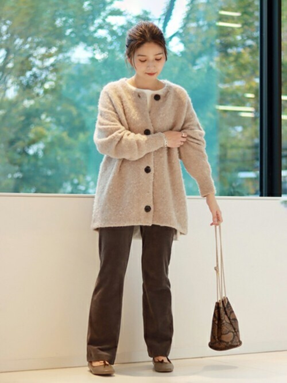 ベージュ系のカーディガン/ボレロ、ベージュ系のその他パンツ、ブラウン系のショルダーバッグを着用したレディースの冬コーディネートの1枚目の写真