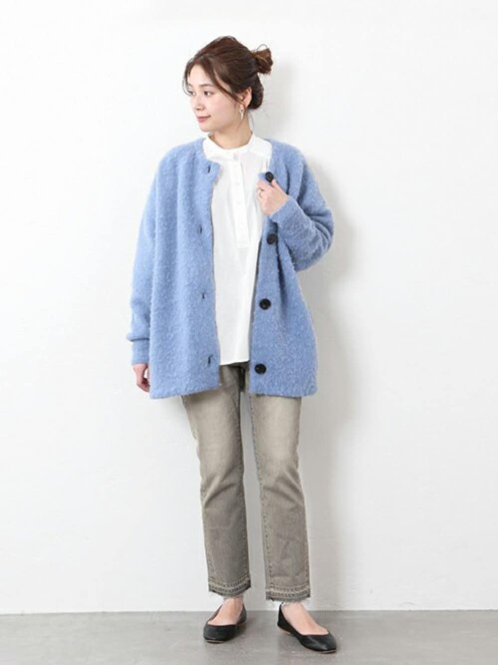 ブルー系のカーディガン/ボレロ、ホワイト系のシャツ/ブラウス、グレー系のデニムパンツを着用したレディースの冬コーディネートの1枚目の写真